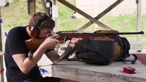 Chico-Caucásico-Entrenado-Para-Disparar-Un-Rifle-En-Un-Campo-De-Tiro