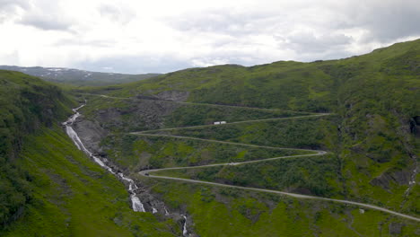 aerial view of cars driving on hairpin turns up a mountain road