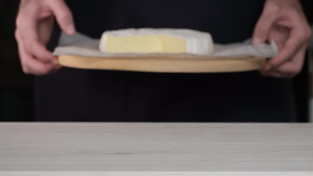 camembert queso crema de primer plano. el chef pone en la mesa con delicioso queso suave camembert. cabeza de queso de leche de cabra con moho blanco. cabeza redonda camembert cortado en pedazos. concepto de producto lácteo