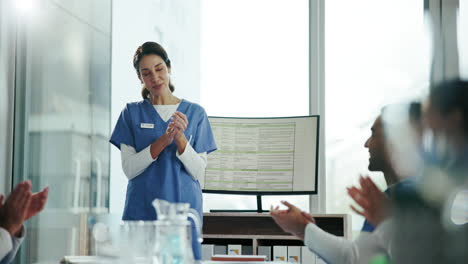 una enfermera hace una presentación a un grupo de profesionales médicos, que aplauden en agradecimiento