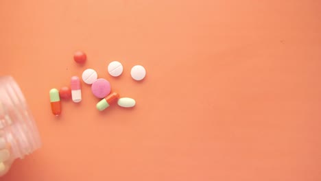 pastillas y cápsulas variadas derramadas de un frasco
