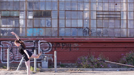 plano general, bailarina hace gaga, edificio industrial abandonado de ladrillo rojo