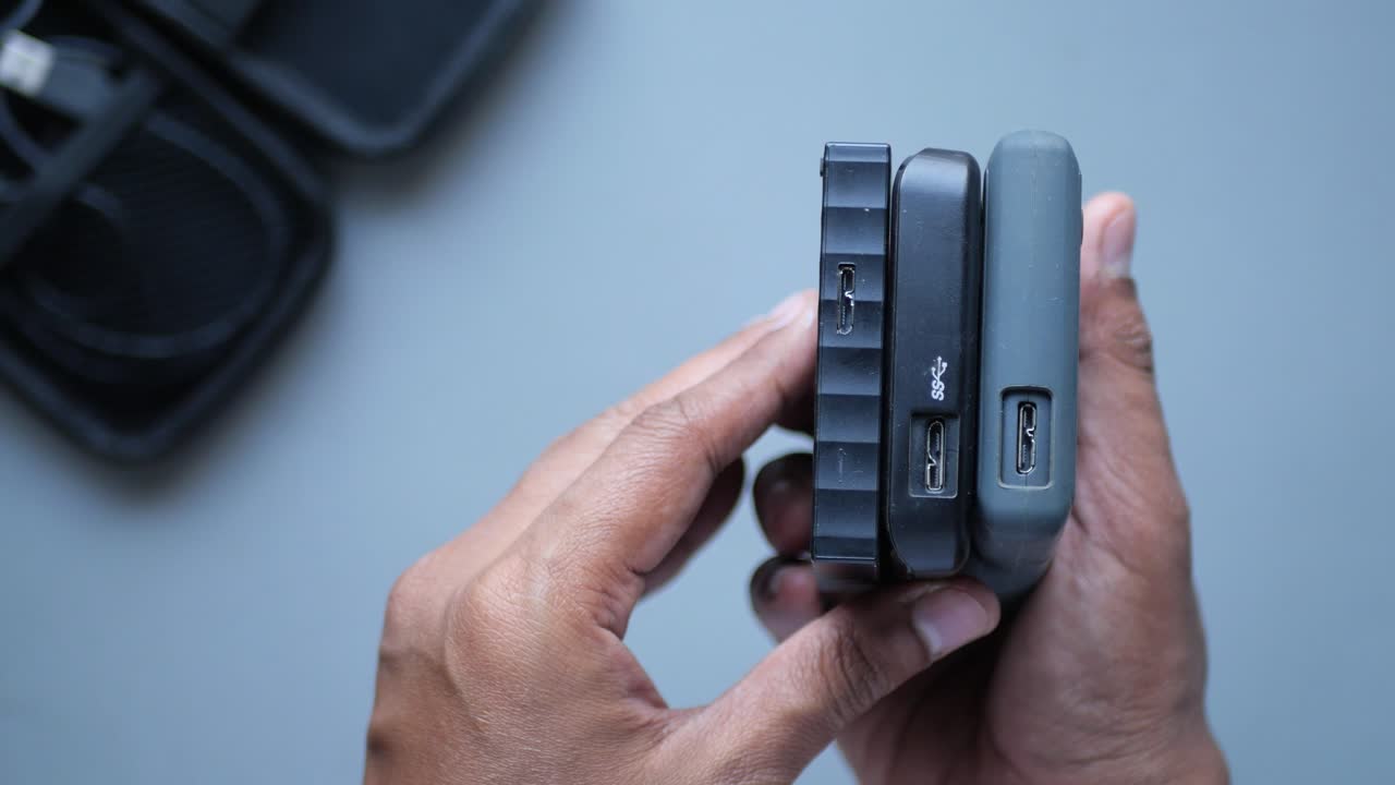 pila de discos duros externos a la mano