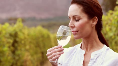 una viticultora girando un vaso de vino blanco
