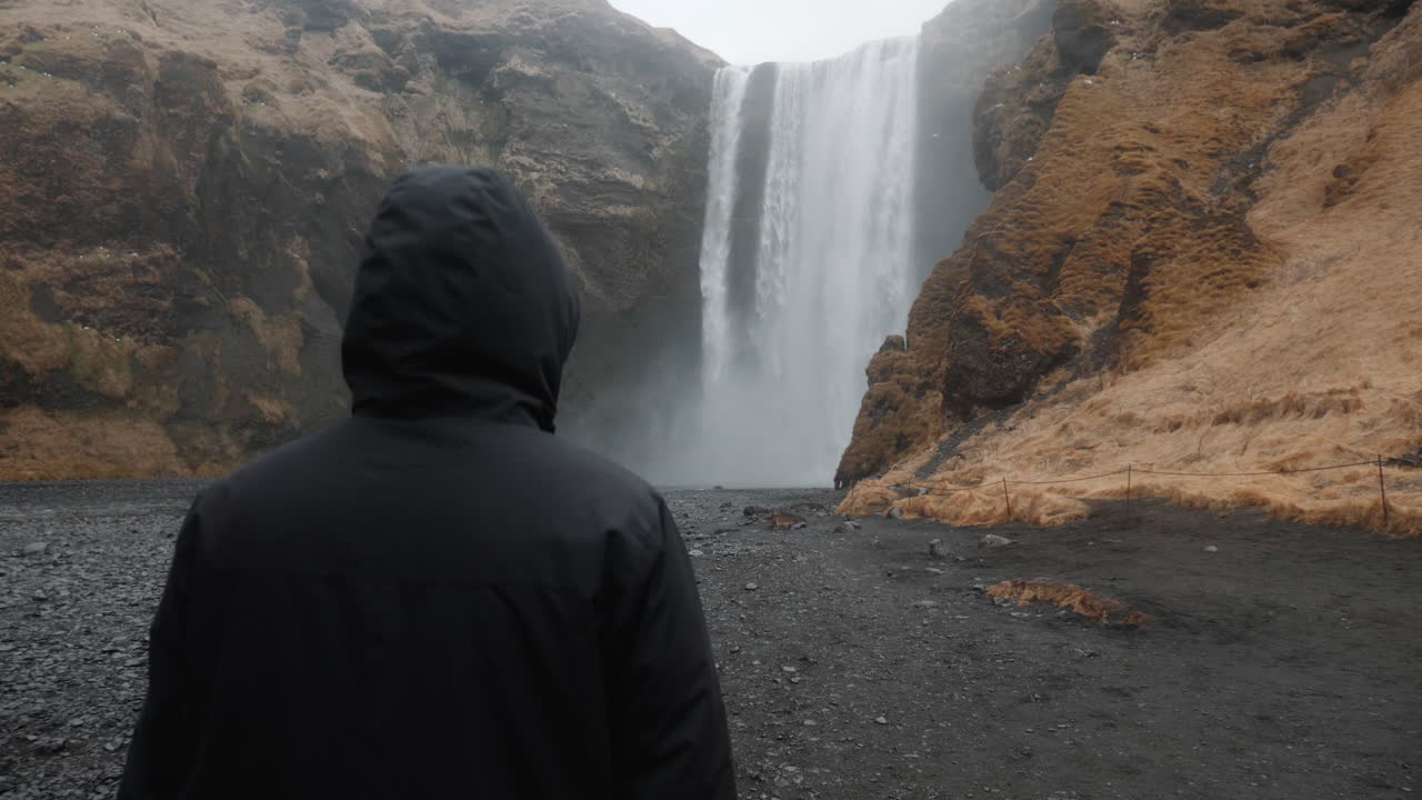 Person standing in front of a waterfall in Iceland