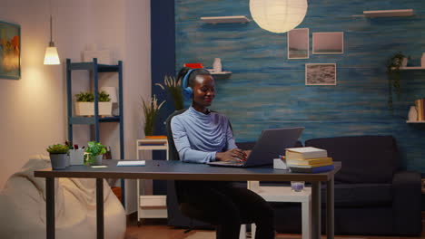 African-woman-listening-music-working-in-loft-interior-overtime