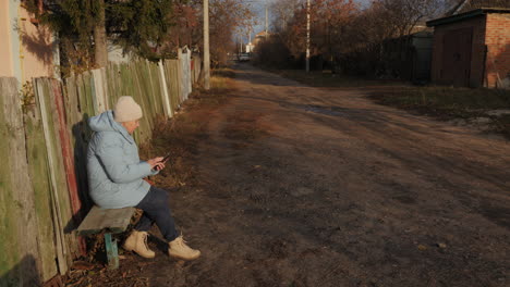 elderly woman using phone in a rural setting