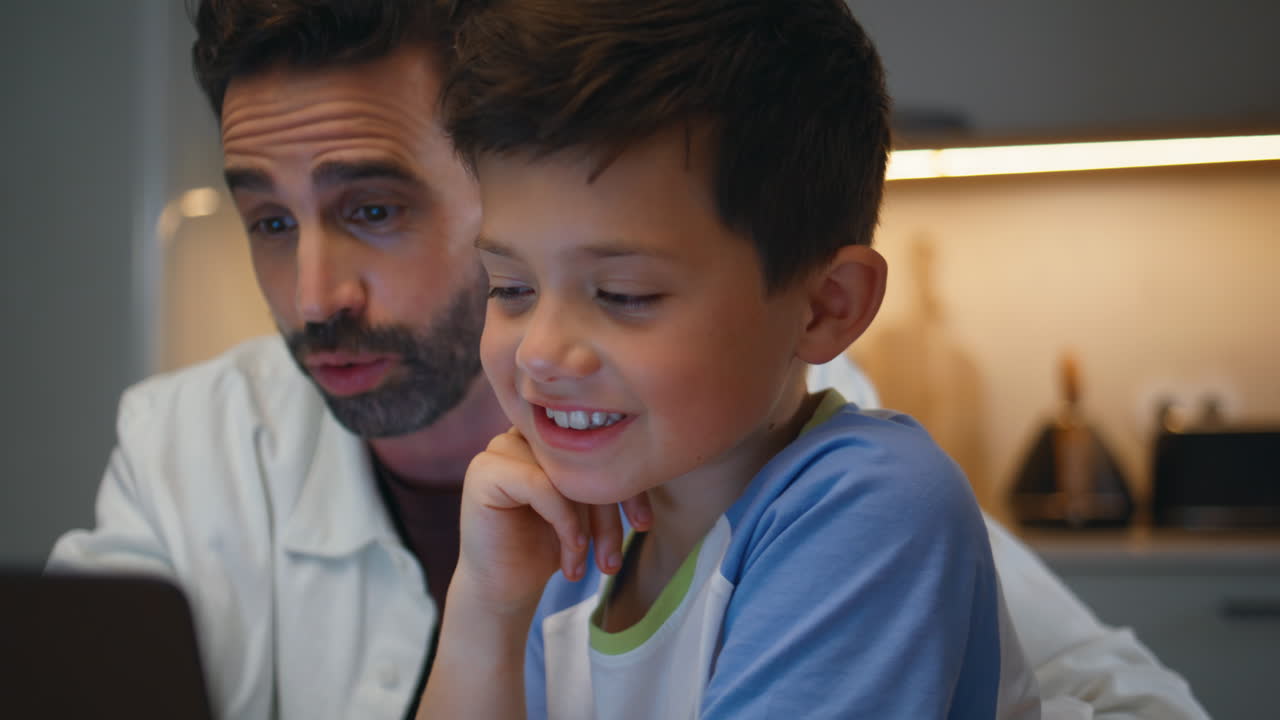 Family enjoying laptop movie relaxing at comfortable home closeup. Parent child