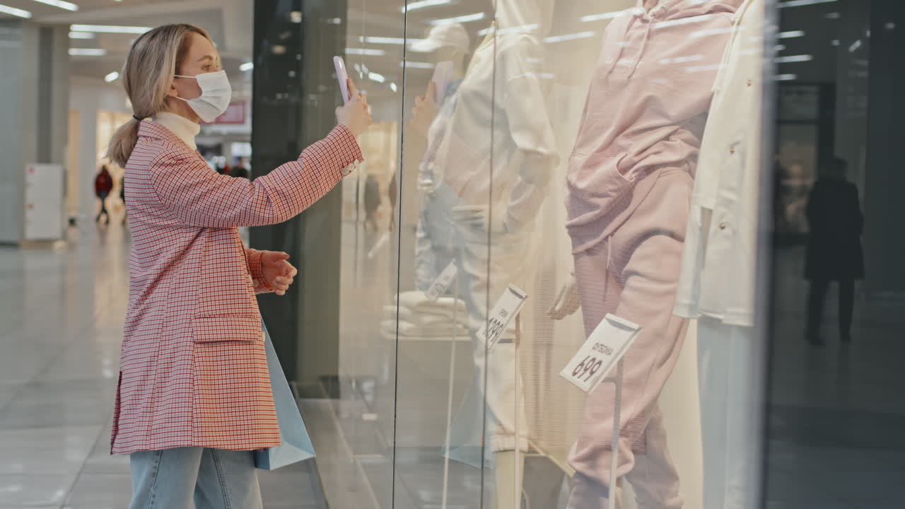 Woman In Face Mask Using Smartphone At Shopping Centre