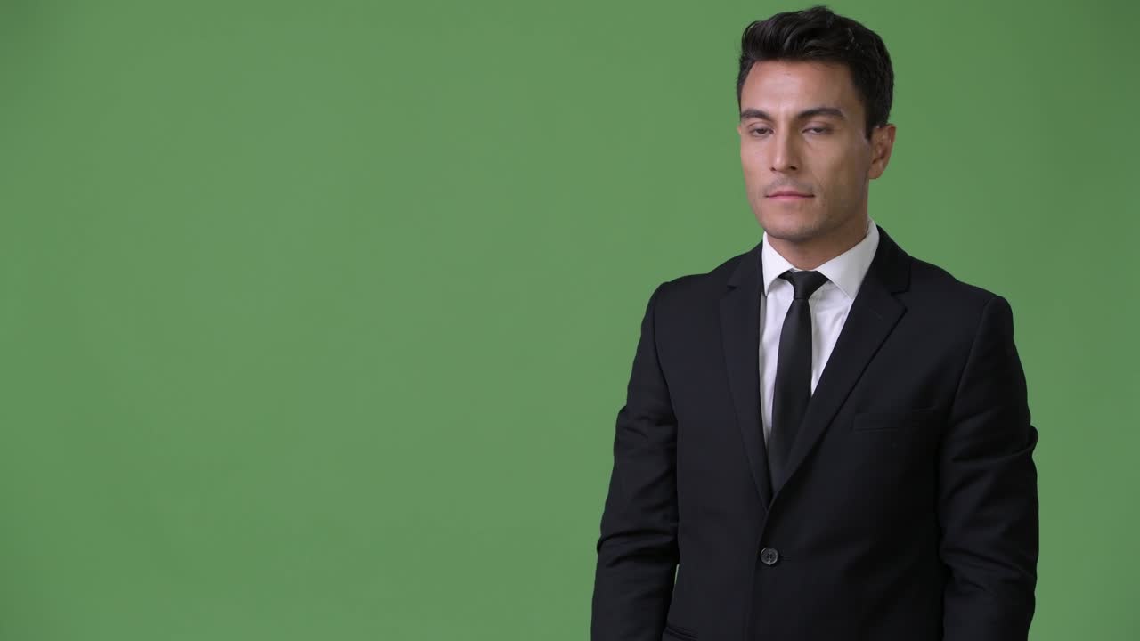 joven y guapo hombre de negocios hispano contra un fondo verde