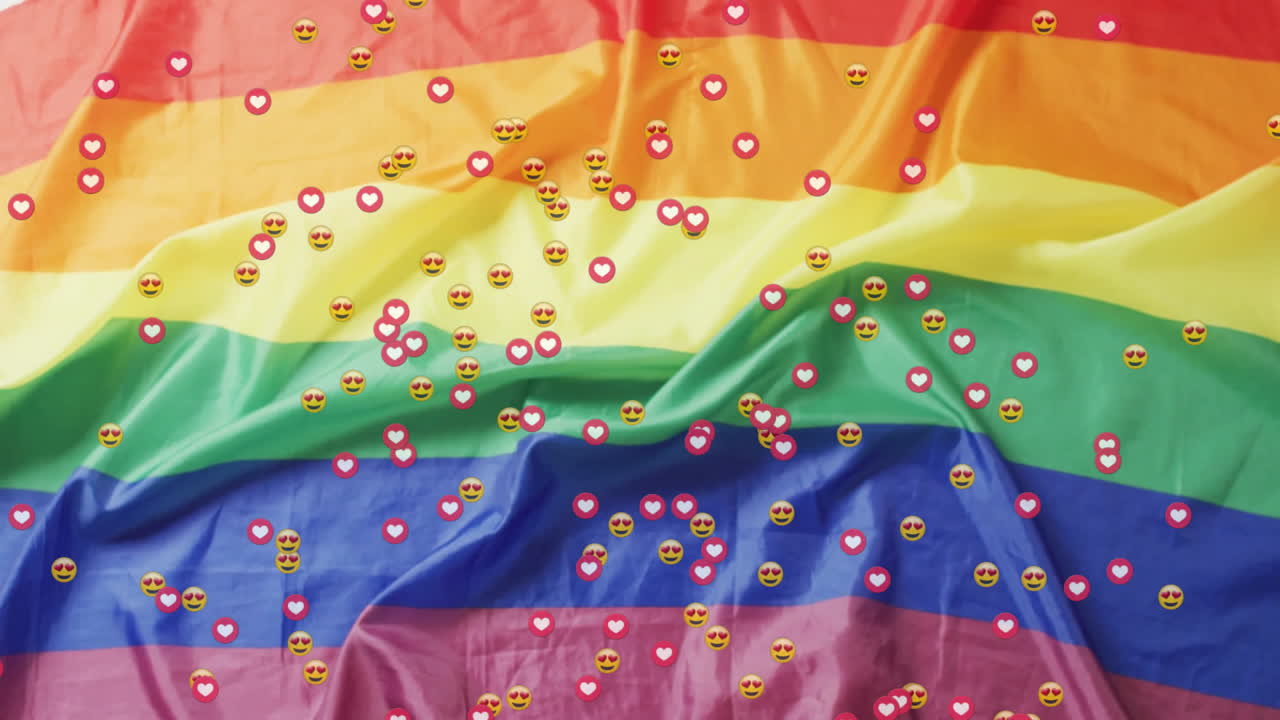 Rainbow Pride flag waving under floating heart reactions and heart-eye emojis across stripes