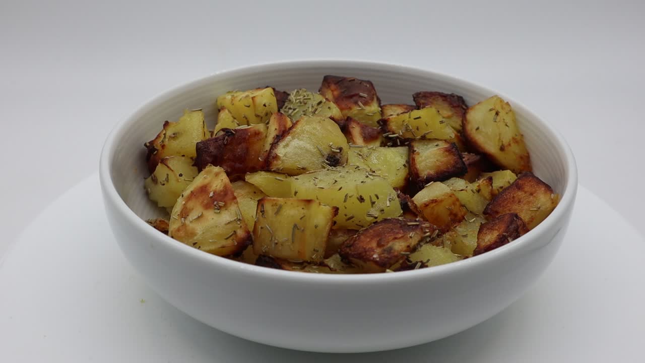 Delicious roasted potatoes with rosemary on turntable