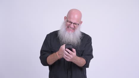 happy mature bald bearded man using phone