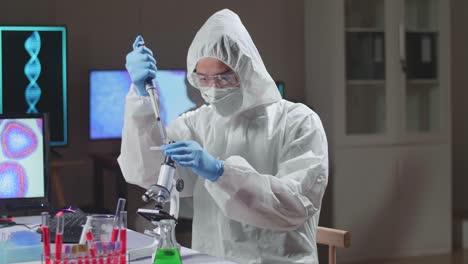 asian doctor in protective suit is doing a science experiments and developing vaccine in a modern lab. laboratory assistant workplace. the concept of science and medicine