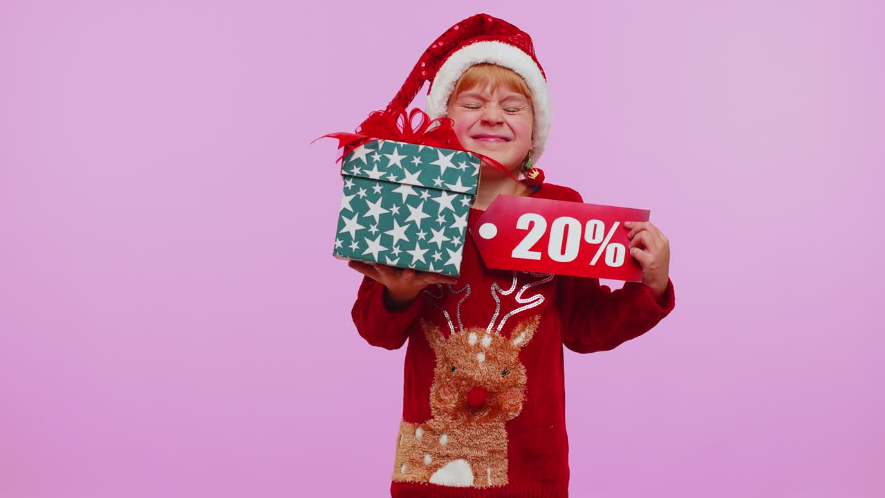 niña pequeña con sombrero de navidad mostrando caja de regalos y 20 por ciento de descuento inscripciones nota de texto de banner