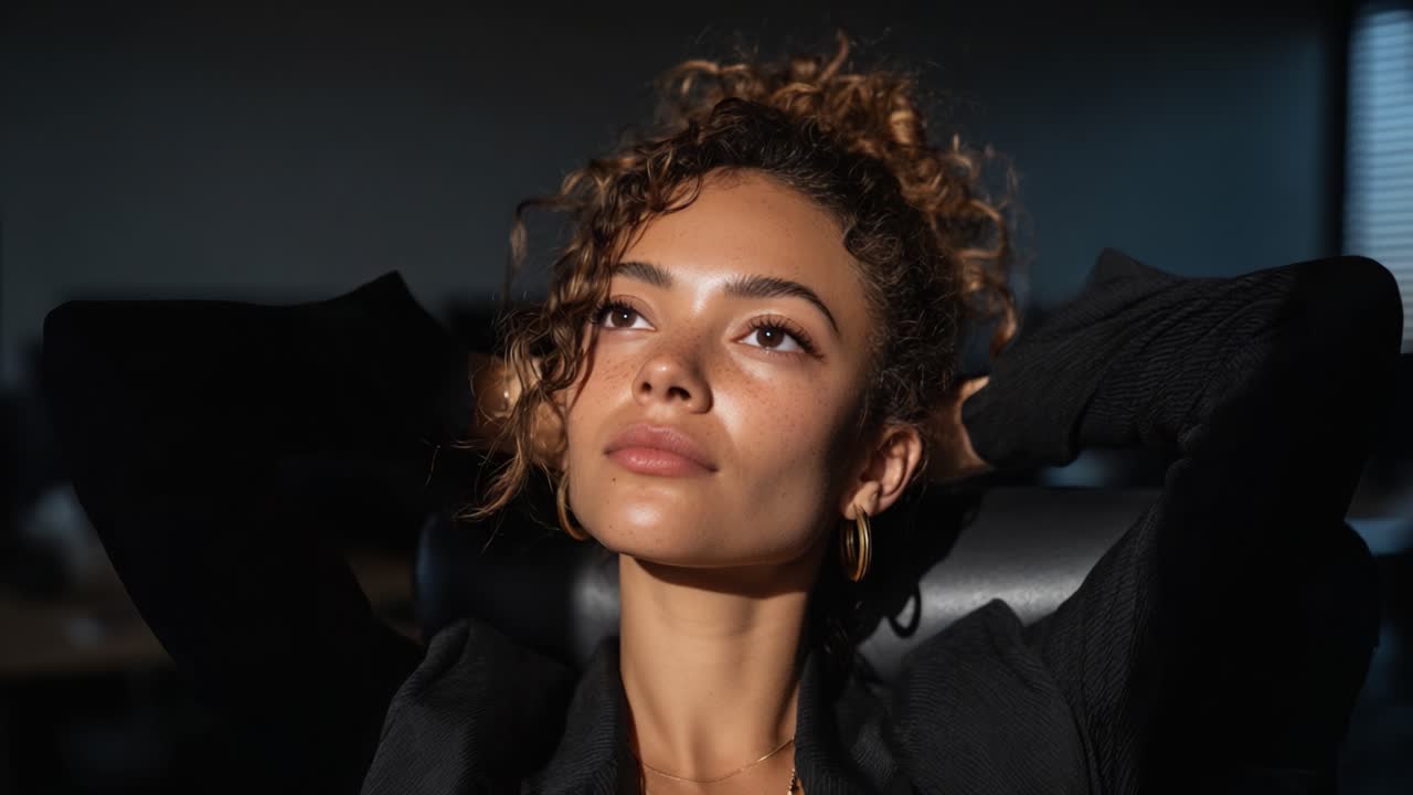 A serene moment captured as a woman relaxes in a soft-lit environment, embodying peace and tranquility with her eyes closed, fully absorbing the calming atmosphere around her