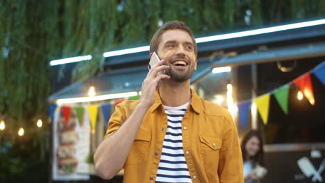 Joyful-Young-Guy-Talking-On-Phone-With-Smile-Outdoor