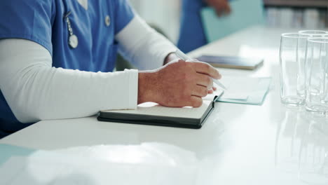 doctor writing notes during a meeting