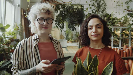 retrato de niñas con planta y tableta en una tienda de flores