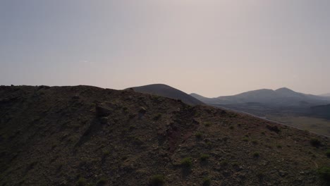 Aerial-Flying-Over-Ridgeline-TO-Reveal-Las-Grietas-Desert-Hilly-Landscape