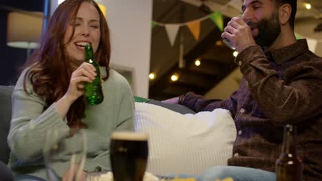 grupo relajado de amigos sentados en el sofá en casa o en el bar celebrando el día de san patricio con fiesta bebiendo alcohol 2