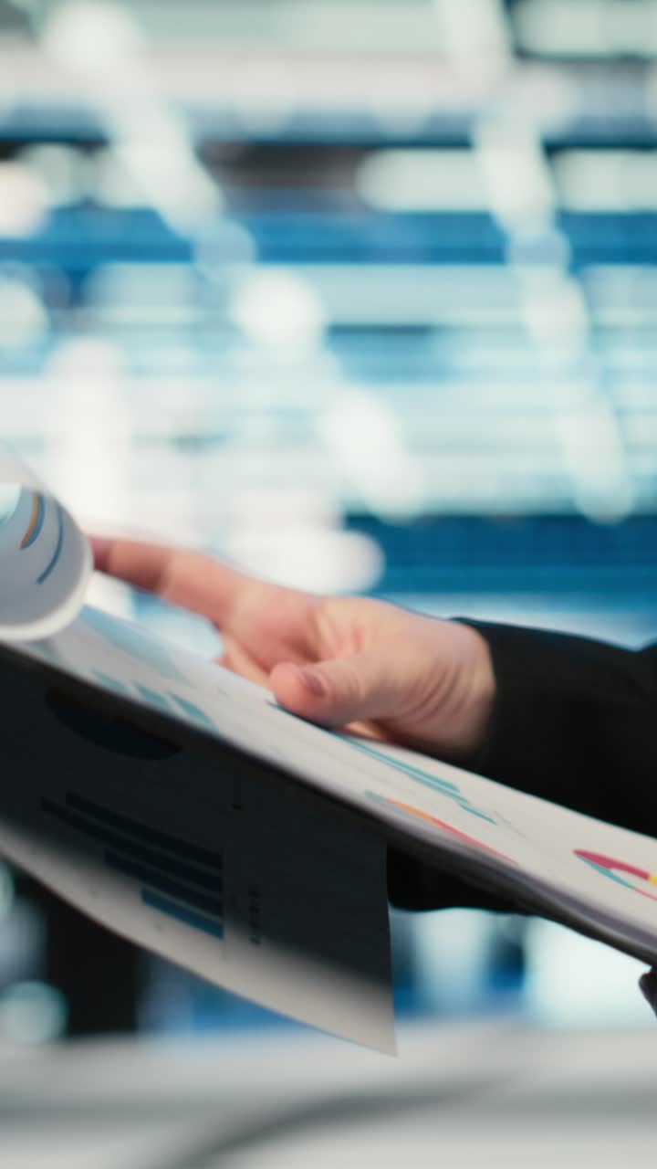 Video verticale: Primo piano di un ingegnere di data center che consulta file e grafici su una cartellina