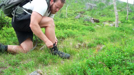 Portrait-Of-A-Man-With-Backpack-Tying-His-Hiking-Boots