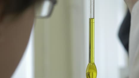 experimento de laboratorio con líquido amarillo en un tubo de ensayo