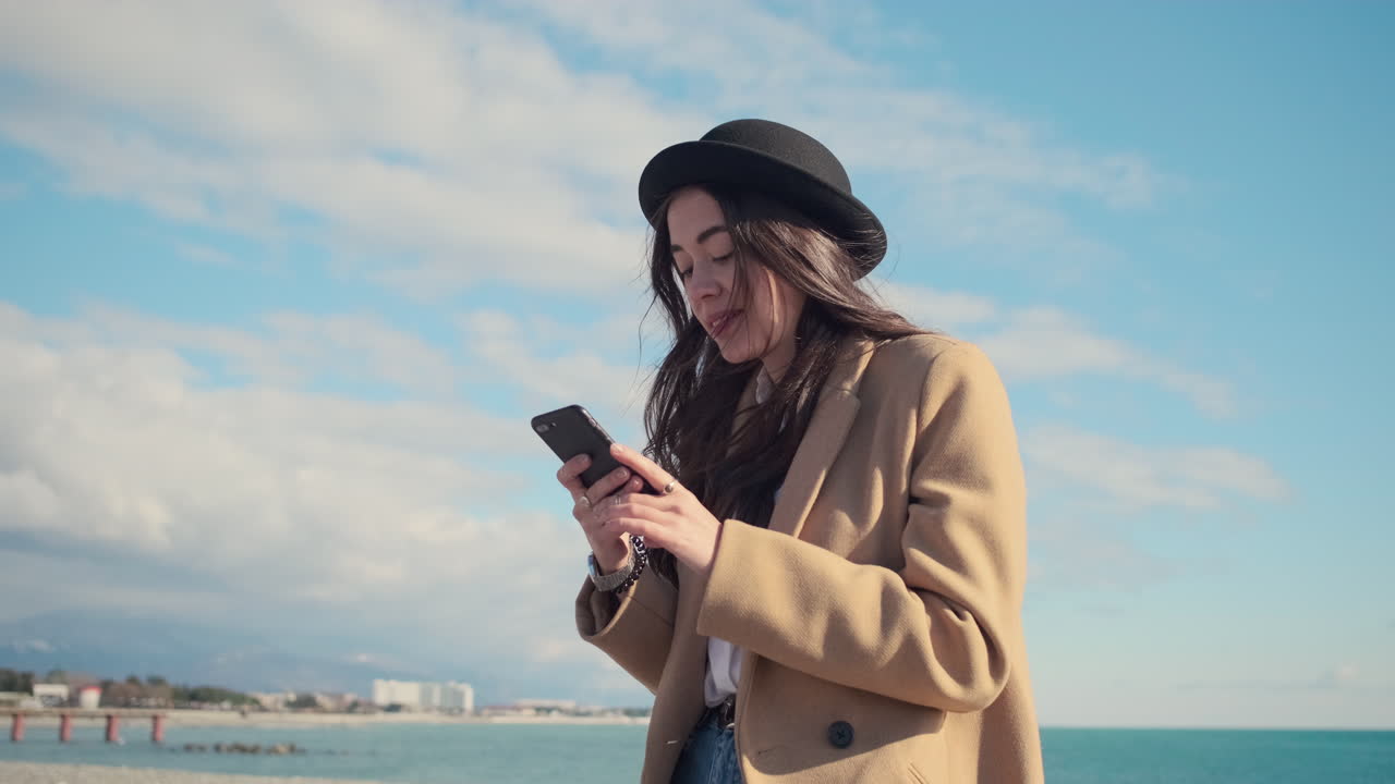 mujer usando el teléfono en la playa
