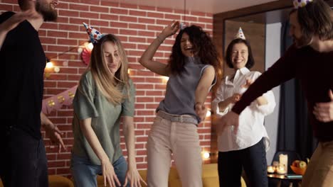 Joyful-friends-dancing-on-birthday-party-celebrating-exciting-holiday-at-home,-slowmo