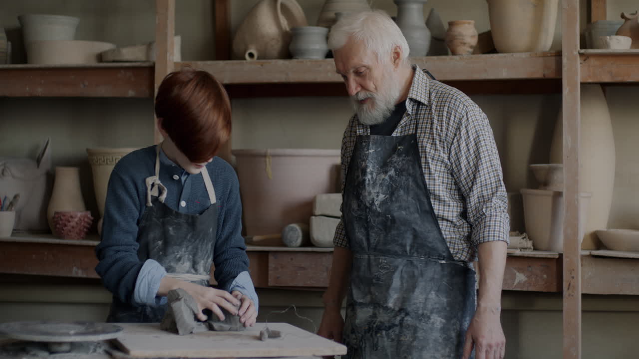 Giovane Apprendista che Impara la Ceramica da un Maestro Esperto