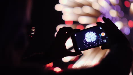 a woman shoots fireworks on a smartphone the lights are beautifully reflected in her glasses 4k 10 b