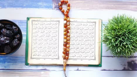 open quran with dates and rosary