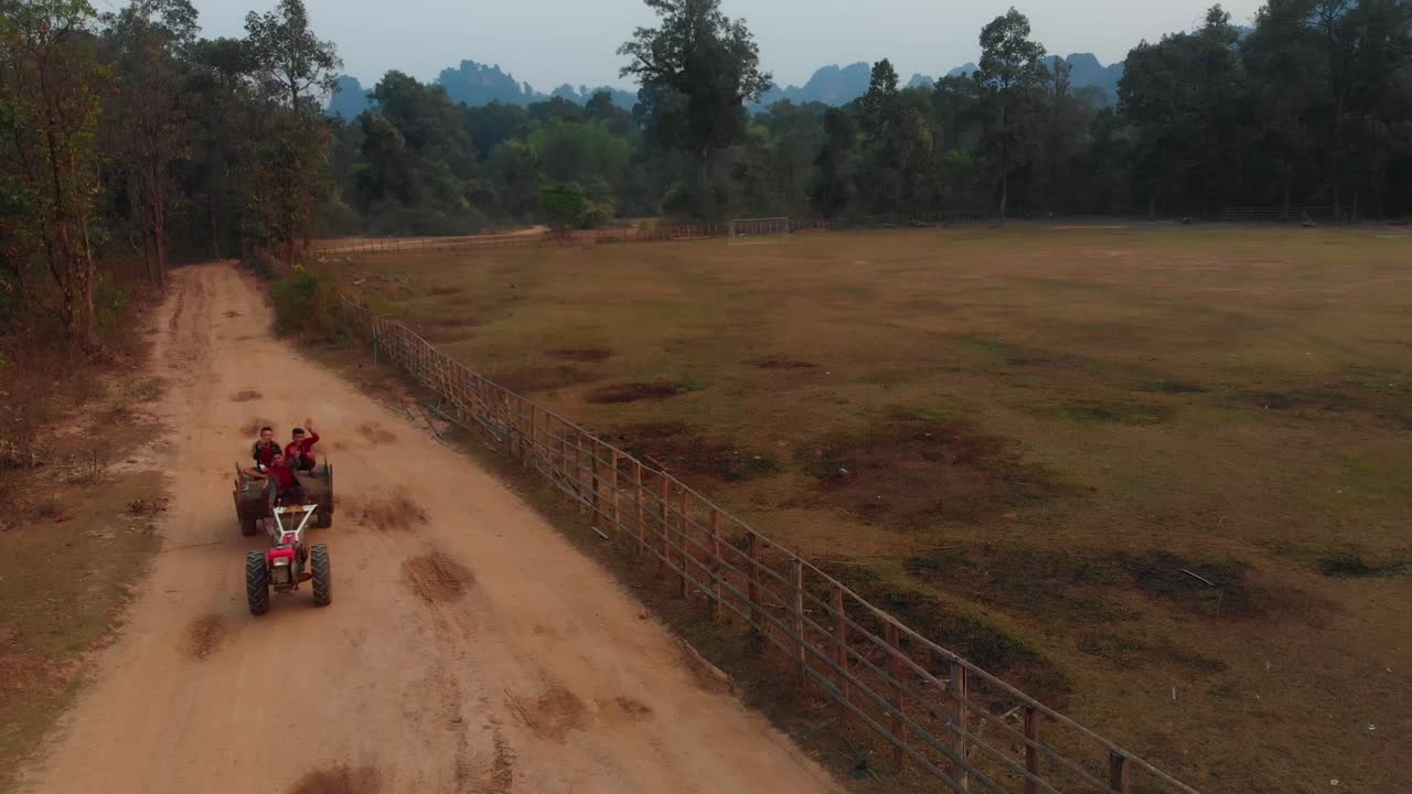 Trattore su strada sterrata con gente del posto a Thakhek, Laos.