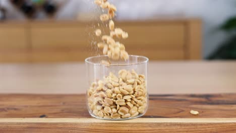 sequence of peanuts filling a clear glass jar