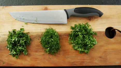 chopped herbs with knife on chopping board 4k