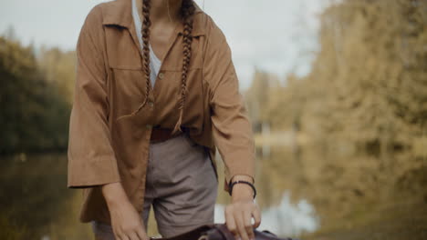 female tourist removing backpack in forest