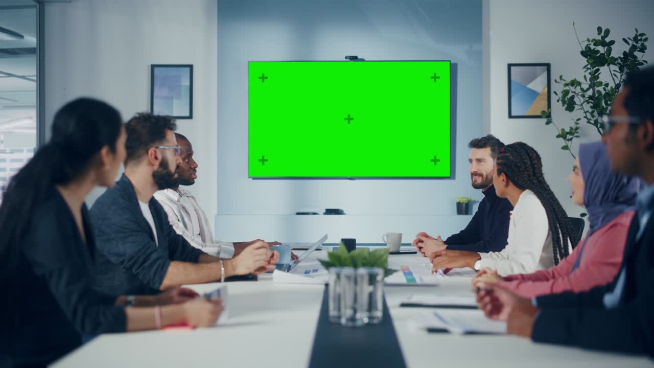 reunión en la sala de conferencias de la oficina multiétnica: equipo diverso de gerentes exitosos, ejecutivos hablan, usan pantalla verde chroma key tv. empresarios invirtiendo en la puesta en marcha de comercio electrónico. tiro estático amplio