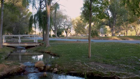 Aerial-fly-over-of-picturesque-creek-or-stream-running-through-beautiful-park