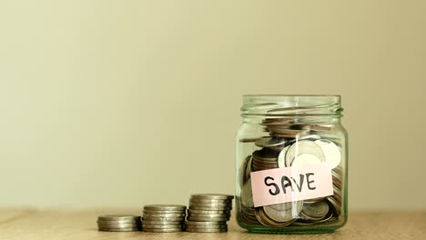 a  money coins falling into the glass jar with label of save text , business and financial of  money saving concept , 4k dci resolution