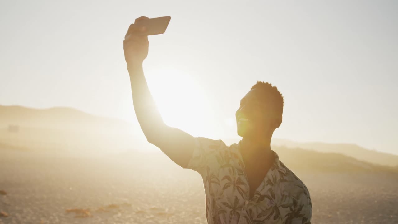 African American man taking a selfie at beach