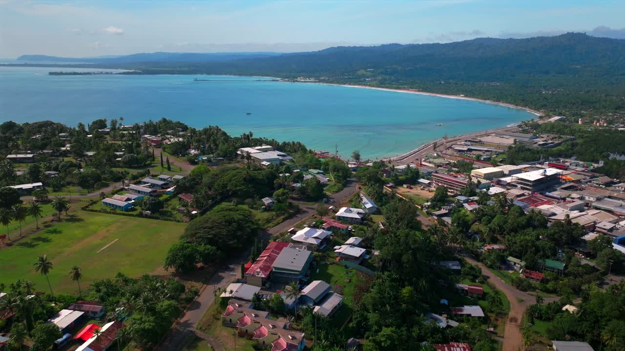 Sunny morning Wewak Papua New Guinea aerial drone dry season Boram Road Wewak Hill costal town Wewak Seawall memorial drive Mini Beach Dogreto Bay shipwreck Sundaun Market backwards pan up motion