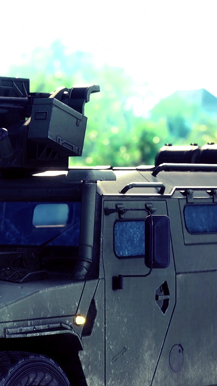 Military vehicle with mounted equipment parked in outdoor setting near hills