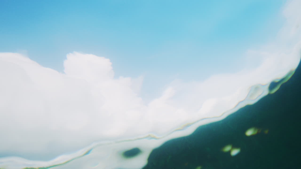 몽환적인 액체 패턴이 물결 뒤에서 왜곡되어 서퍼가 은 물에서 타는 것처럼