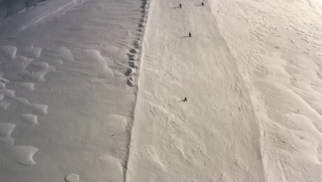 AERIAL---People-slalom-skiing-in-mountains-at-Kolasin-ski-resort,-Montenegro,-reverse