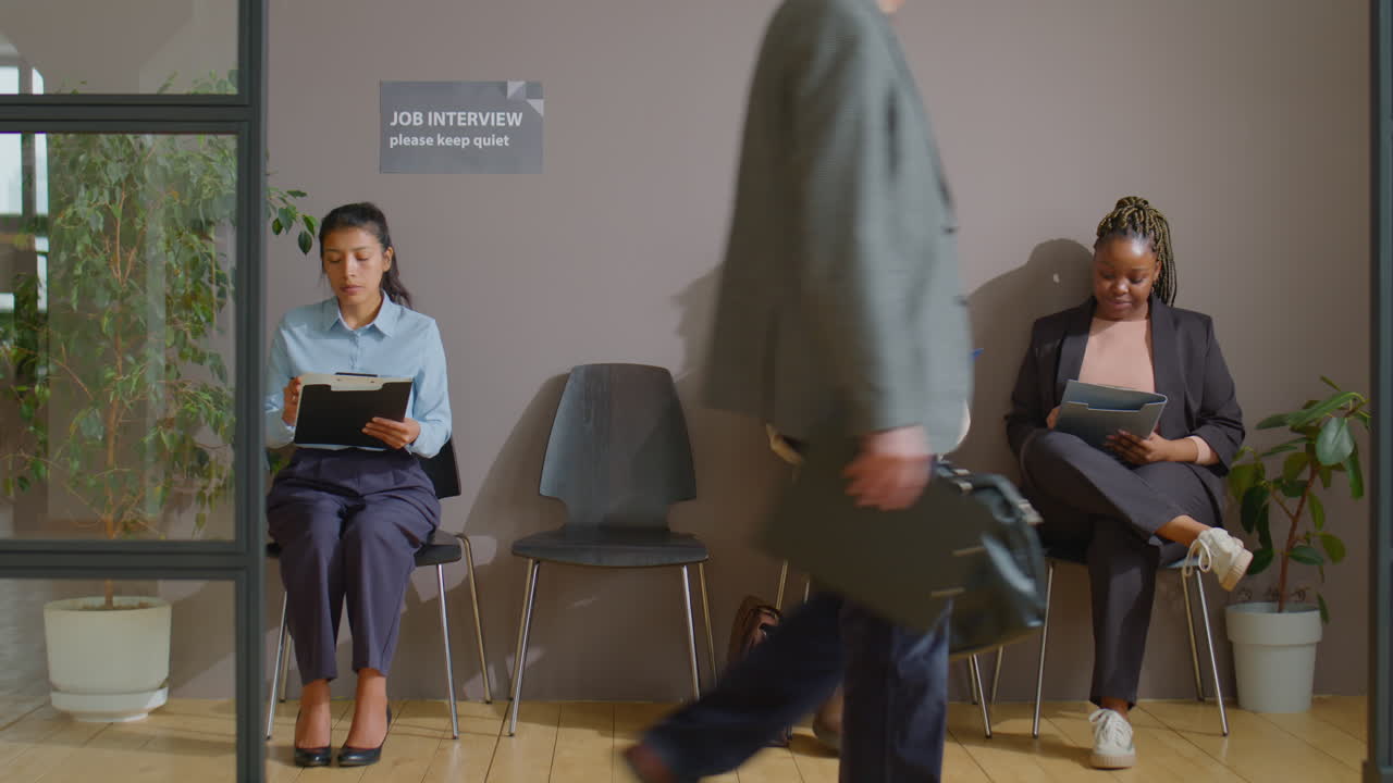 Businesspeople Filling Papers in Queue for Job Interview