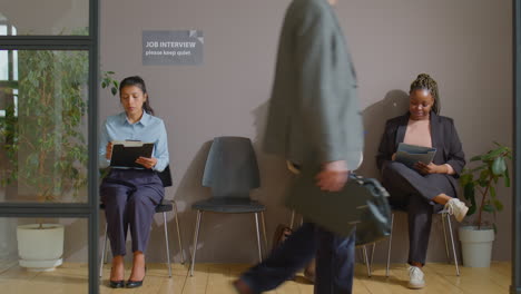 businesspeople filling papers in queue for job interview