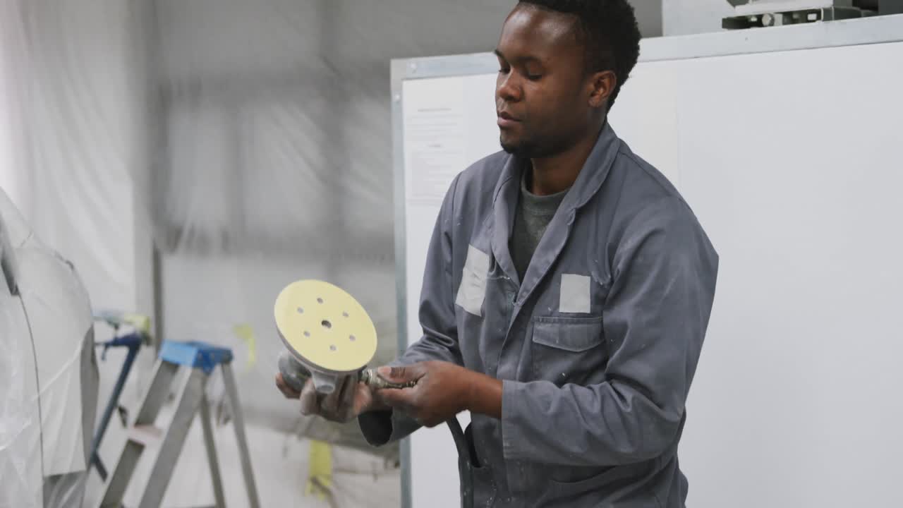 African American male car mechanic working and  checking and connecting a tool