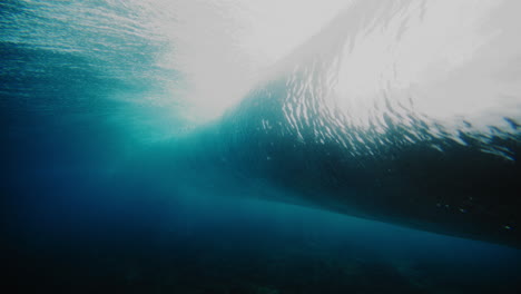 dark mystic water rises into stunning clear barrel with mist and foam at cloudbreak fiji
