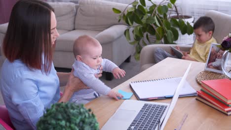 young mother spending time with children while working